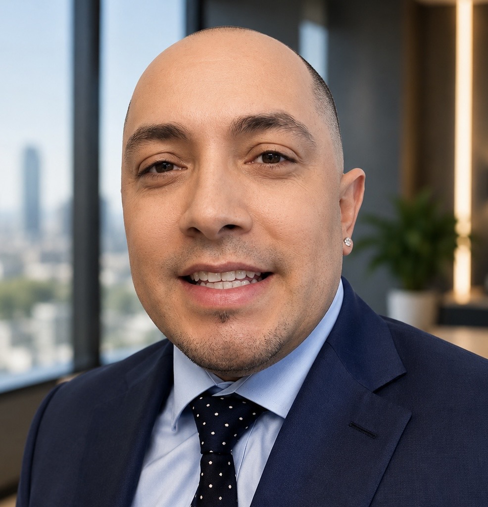 Edward Alan Vasquez, professional headshot in a navy suit and tie